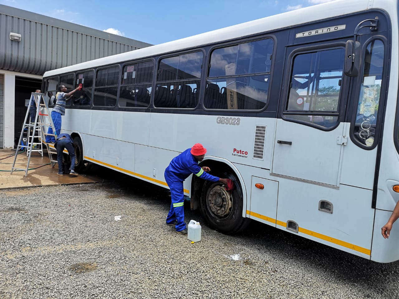 Cleaning crew washing a Putco bus at the depot