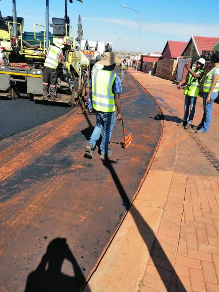 Asphalt road resurfacing crew laying new road surface